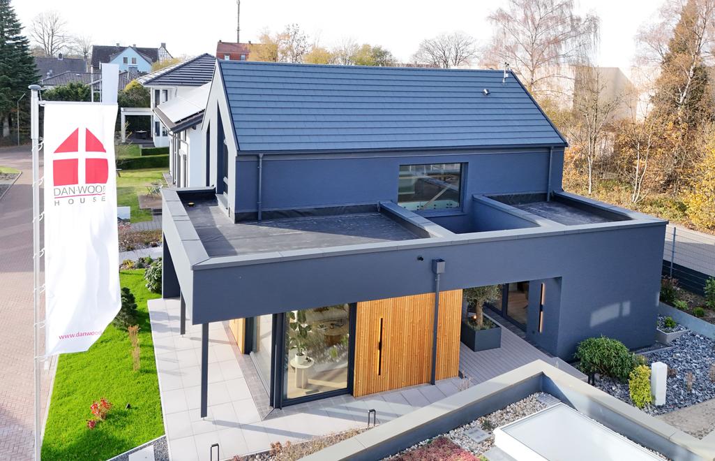 Fassade des Musterhauses S-Linie in Wuppertal mit Holzverkleidung und Flachdach – Ansicht Gartenseite