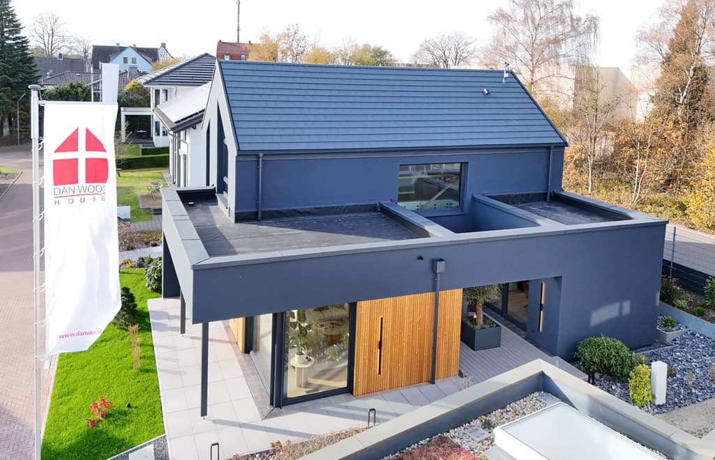 Fassade des Musterhauses S-Linie in Wuppertal mit Holzverkleidung und Flachdach – Ansicht Gartenseite